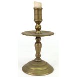 A 17th century style brass candlestick, with wide circular drip pan,