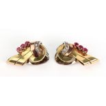 A pair of ruby and diamond set earclips designed as scrolls,