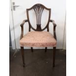A Hepplewhite style mahogany elbow chair, the shield shape back with wheatear carved pierced splat,
