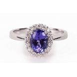 An 18ct white gold, tanzanite and diamond oval cluster ring,