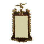 A George II and later red walnut and parcel gilt upright wall mirror, of shaped outline,