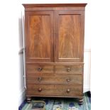 A late George III mahogany linen press, the moulded cornice above a pair of panelled doors,