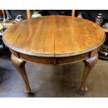 An early 20th century oak extending dining table,