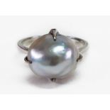 A baroque pearl ring, the slightly grey tinted bead approximately 11-13mm diameter,