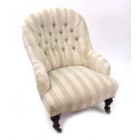 A Victorian button down upholstered armchair, circa 1870, on turned mahogany legs and castors.