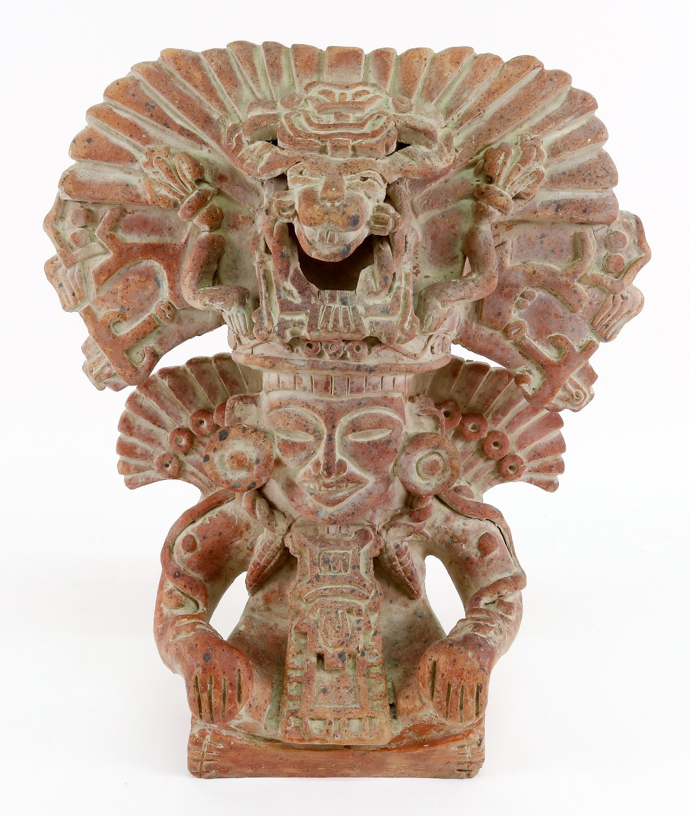 A terracotta South American figure of a man in an elaborate head dress, 39cm high.