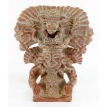 A terracotta South American figure of a man in an elaborate head dress, 39cm high.