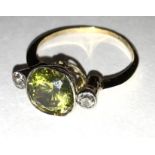 A diamond and yellowish-green stone three stone ring,