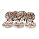 Seven Japanese Imari plates, Meiji period, painted with panels of figures seated on a terrace,