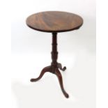 A George III mahogany pedestal table, the circular tilt-top on a vase turned pillar and tripod base,