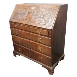 A mid 18th century oak bureau, the hinged fall later foliate carved and enclosing a fitted interior,