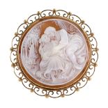A modern 9ct gold and shell cameo round brooch, the cameo depicting lovers seated in a forest glade,