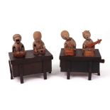 Two carved wooden Japanese Kobi toys, both with two figures on top of a box,