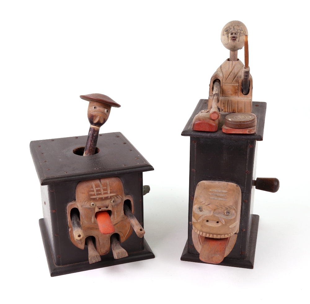 Two carved wooden Japanese Kobi toys; one with a man on top of a wooden box playing a drum,