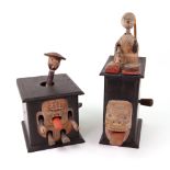 Two carved wooden Japanese Kobi toys; one with a man on top of a wooden box playing a drum,
