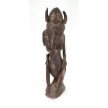 A tribal carving of a figure, with painted sections to face, shoulder and legs, 95cm high.