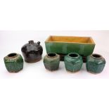 A Chinese green and ochre glazed rectangular stoneware jardiniere, raised on four bracket feet,