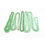 A mottled light green glass bead long necklace of uniform beads,