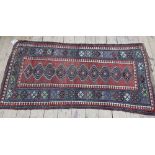 A Kazak rug, early 20th century, with narrow field and ten section medallion, within red,
