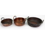 A collection of three Victorian copper and brass preserve pans, each with twin raised side handles,