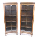 A pair of narrow reproduction mahogany dwarf bookcases, each enclosed by a glazed panel door,