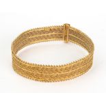 A yellow metal bangle, probably Indian, 20th century, formed of two plaited rope-twist bands,