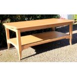A contemporary low two tier centre table, the moulded rectangular top with shaped ends,