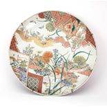 A Japanese Imari charger, Meiji period, painted with birds in a fenced garden,