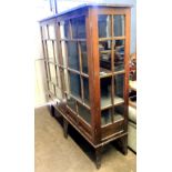 An Arts & Crafts oak display cabinet, enclosed by a pair of glazed doors with glazed side panels,