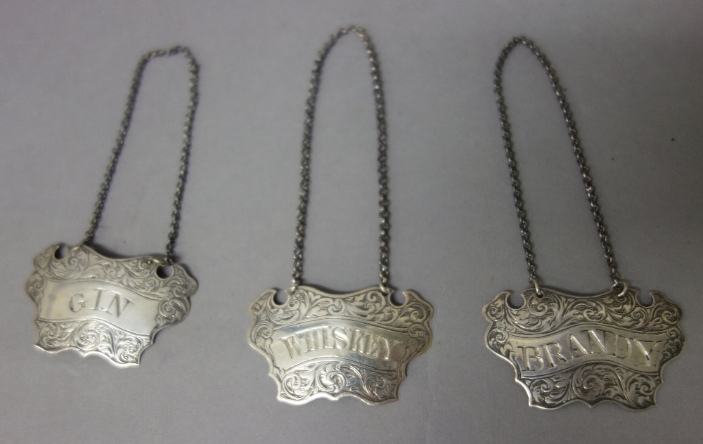 A pair of Victorian silver decanter labels, each of cartouche shaped form, detailed Brandy and Gin,