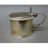 A William IV silver hinge lidded mustard pot of cylindrical form, decorated with a gadrooned rim,
