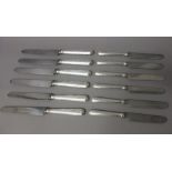 Sixteen steel bladed table knives, having loaded silver handles, the hallmarks generally worn,