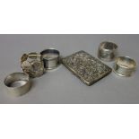 Four silver napkin rings, in a variety of designs,