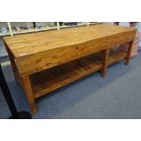 A 20th century waxed pine work bench, with plank top and undertier, on block supports,
