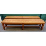 A pair of late Victorian oak benches, each on six tapering square supports united by stretcher,