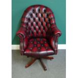 A 20th century office swivel chair, with brass button faux rouge leather upholstery,