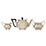 A silver three piece tea set, comprising; a teapot having black fittings,