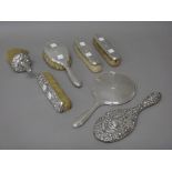 A silver mounted four piece dressing set, with engine turned decoration, comprising; a hand mirror,