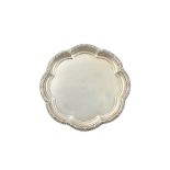 A silver salver, of shaped circular form, having a decorated rim,