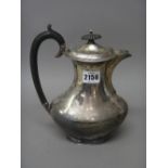 A silver hot water jug, of oval baluster form, having wooden fittings, Sheffield 1930,