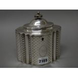 A George III silver hinge lidded tea caddy, of panelled oval form, having engraved decoration,