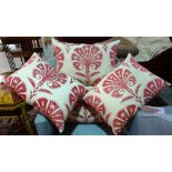 A group of four 20th century cream cushions with red patterned decoration, (4).