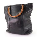 A black leather Gucci handbag, with bamboo handles, the leather zip pull embossed 'GUCCI',