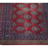 Two Pakistan Bokhara rugs, one with a red ground, the other a blue ground,