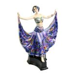 A Goldscheider hand decorated pottery figure of a dancer, standing on a concave sided plinth base,