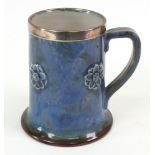A silver mounted Royal Doulton Art pottery mug,