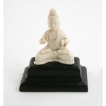 An Indian carved ivory figure of a seated Buddha on stepped ebony plinth base, 11cm high,