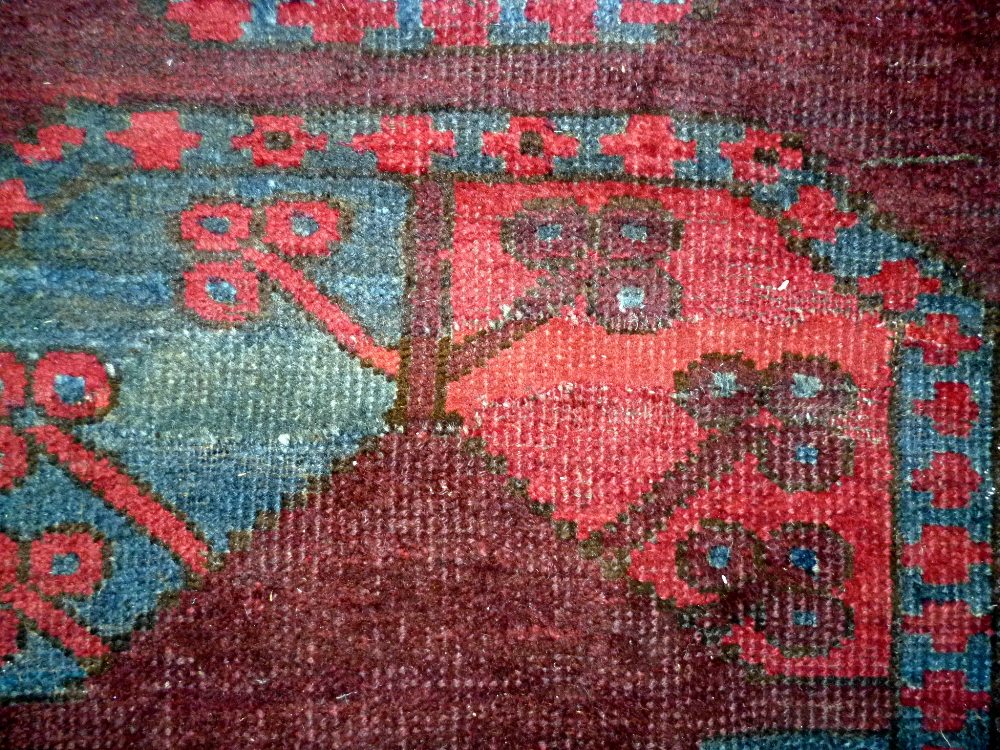 An Afghan Esari carpet, the dark madder field with three columns of six bold guls, - Image 9 of 12