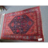 A Hamadan rug, Persian, the indigo field fitted with angular flowering branches,