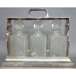A silverplated three bottle cased tantalus, early 20th century, with locking mechanism,